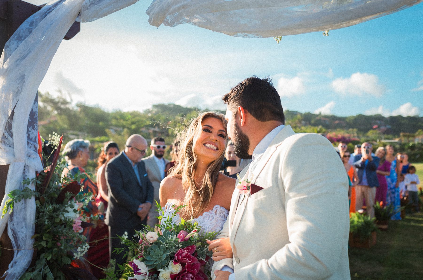 Bride and groom at an outdoor ceremony under a white canopy